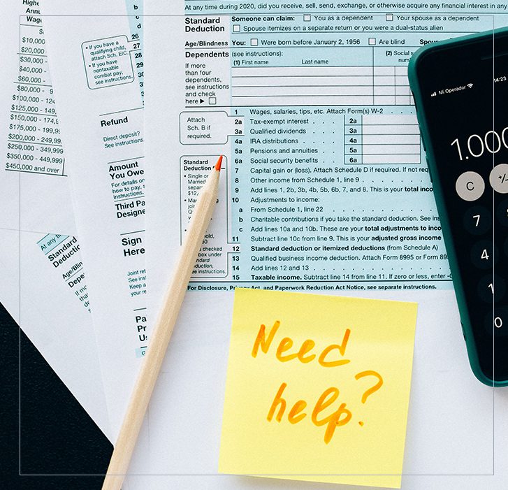 A pen, calculator and some papers on top of a table.