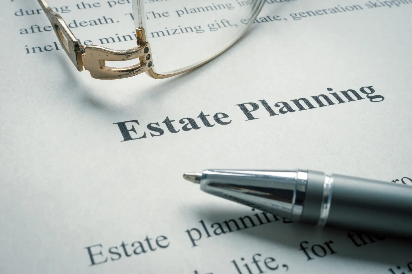 A pen and glasses on top of an estate planning document.